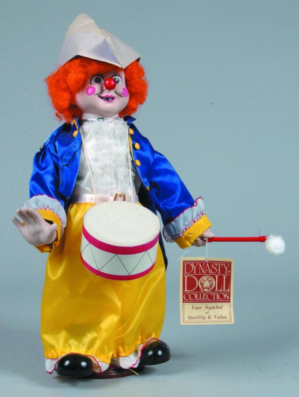 Happy the Drummer Dynasty Doll, painted bisque hea: Happy the Drummer Dynasty Doll, painted bisque head and hands, clown costume with drum, 16" l., paper hat crumpled, otherwise very good.
