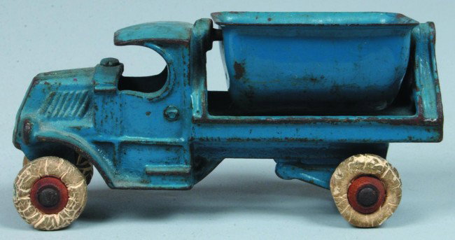 Dent Cast Iron 665 C-Cab Dump Truck, original blue: Dent Cast Iron 665 C-Cab Dump Truck, original blue paint with white rubber tires, steel swivel side dump, 5" long. Condition: good with edge wear and minor rust, tires intact but show cracking.