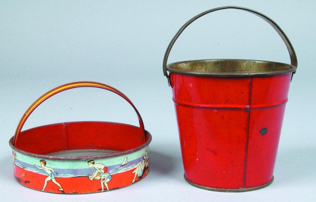 Two Tin Lithographed Sand Toys, sieve with handle,: Two Tin Lithographed Sand Toys, sieve with handle, 6-1/2" x 1-1/2" h., marked Ohio Art Co., Dayton O., wear to edges, otherwise good, bucket with handle 5" h. x 5-1/4" diam.