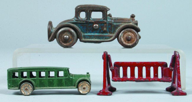 Three Painted Cast Metal Toys: an Arcade cast iron: Three Painted Cast Metal Toys: an Arcade cast iron 5-window coupe, 4-1/4" l., paint rough, fair condition; a Painted die cast omnibus, no maker marks, 3-1/2" l., good; and a Painted cast iron porch sw