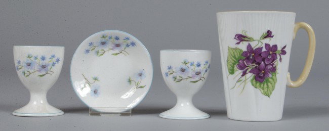 Lot of Shelley China: Two Blue Rock pattern Egg Cu: Lot of Shelley China: Two Blue Rock pattern Egg Cups and Butter Pat, egg cup 2-1/2" x 1-7/8" d. (one cracked with rim chip), and butter pat 3" diam., (good), and Violets pattern Handled Cup, 4" h. x 2