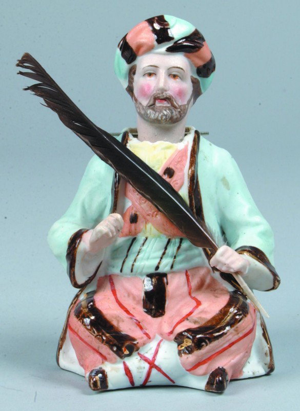 Bisque Arabian Nodder Figurine, seated male figure: Bisque Arabian Nodder Figurine, seated male figure wearing a turban and holding a feather in one hand, hand painted, nodding head, unmarked. 5" high. Condition: good.