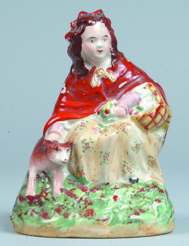 Staffordshire China Little Red Riding Hood Figurin: Staffordshire China Little Red Riding Hood Figurine, hand painted girl with basket and wolf by her side. 6" high. Condition: good with minor paint loss.