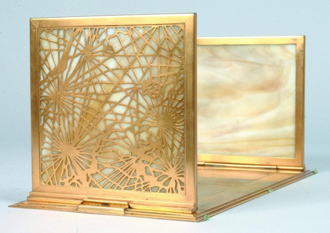 Tiffany Book Rack from John Lennon's Estate.: Tiffany Caramel Slag Glass and Gilt-Bronze Telescoping Bookrack, 1899-1920. "Spiderweb" pattern enclosing mottled amber slag glass; the side panels flanking an adjustable base; impressed "TIFFANY STUD