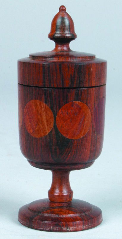 Jacob E. Brubaker Saffron Cup, 2.5"d. x 6"h., turn: Jacob E. Brubaker Saffron Cup, 2.5"d. x 6"h., turned lidded rosewood cup with acorn finial, 7 moon phase medallions inlaid in side. Signed on bottom: "JEB '75". Condition good