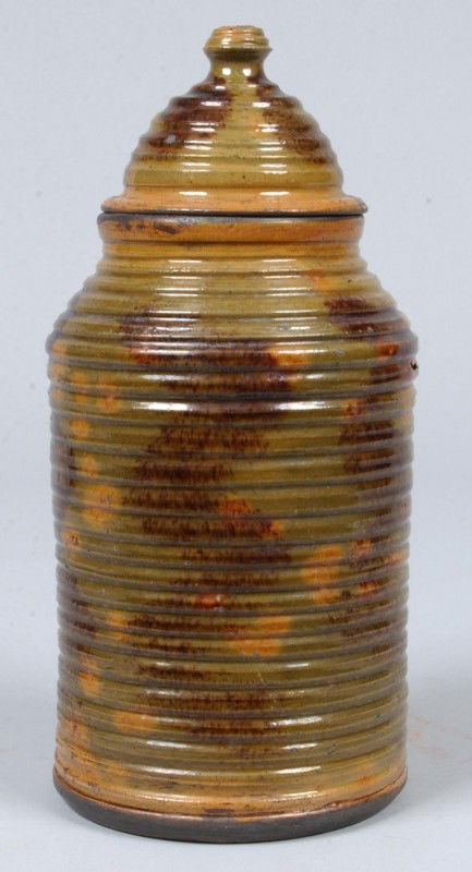 Greg Shooner 2005 Glazed Redware Pottery Ring-turne: Greg Shooner 2005 Glazed Redware Pottery Ring-turned Cylindrical Form Canister with dome lid with green, brown and orange mottled glaze. 10" high. Condition: good with intentional wear.