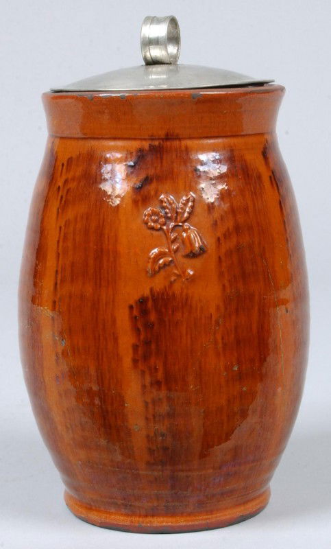 Greg Shooner 2003 Brushed Glazed Redware Pottery Bu: Greg Shooner 2003 Brushed Glazed Redware Pottery Bulbous Form Canister with double embossed floral and foliate decoration and having a tin lid, 8 3/4" high overall. Condition: good with intentional we