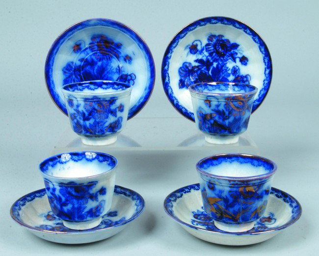 Four Flow Blue Ironstone Handless Cups and Saucers: Four Flow Blue Ironstone Handless Cups and Saucers, 3"h. x 6"d.; 12 paneled with copper luster accents. Marked:"Flora, C.C. & Co. and impressed PEARL". Condition: crack on one cup o/w Good