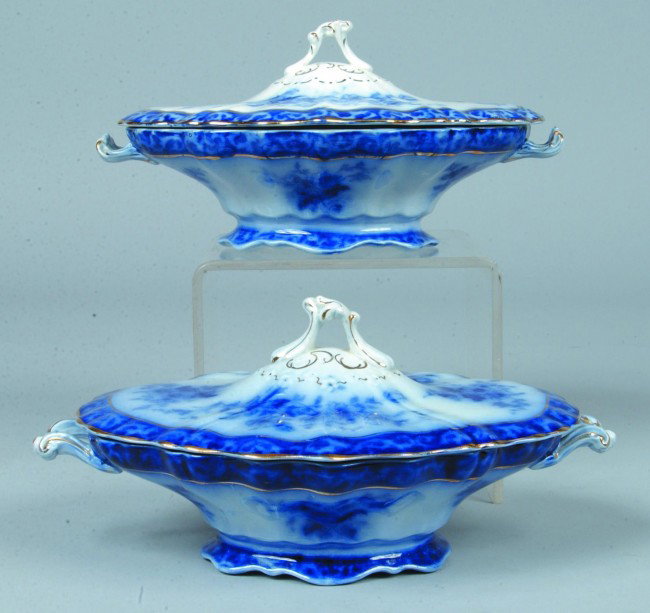 Two Flow Blue Ironstone Covered Vegetable Dishes,: Two Flow Blue Ironstone Covered Vegetable Dishes, 10"l.; gold accented Touraine design. Marked: Stanley and Henry Alcock Pottery Co. Condition: One chip on each lid.