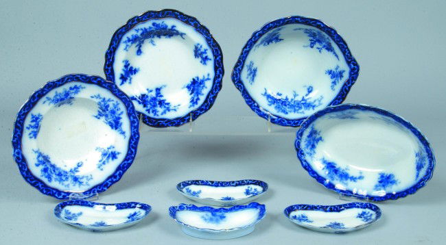 Eight Pieces Flow Blue Ironstone Tableware, Oval v: Eight Pieces Flow Blue Ironstone Tableware, Oval vegetable 9 1/2"l., Round vegetable 9"d., Soup Plates 8 3/4"d., Bone Dishes 6 1/4"l. Condition: two small chips on one soup plate.
