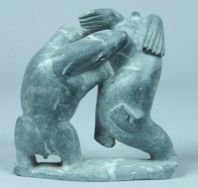 Native Soapstone Carving, 7 1/2"h.; a bear biting: Native Soapstone Carving, 7 1/2"h.; a bear biting into the abdomen of an upended seal on base. All one piece of stone. Condition: Good, illegible inscription on bottom except for date, 1968.