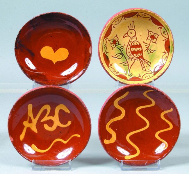 Four Contemporary Redware Dishes, 4"dia.; three re: Four Contemporary Redware Dishes, 4"dia.; three red with yellow slip decorations, squiggles, heart and ABC also one with full yellow slip and inscised decorative design of bird and flowers with draped