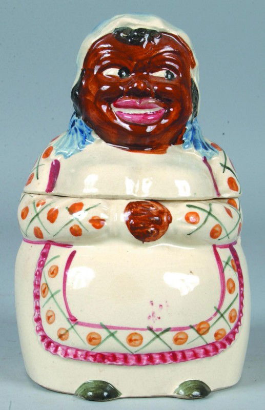 Black Memorabilia Ceramic Cookie Jar, 10"h.; non-t: Black Memorabilia Ceramic Cookie Jar, 10"h.; non-traditional Mammy character with under-glaze paint decoration to mold features. Marked: Made in Japan. Condition: Good