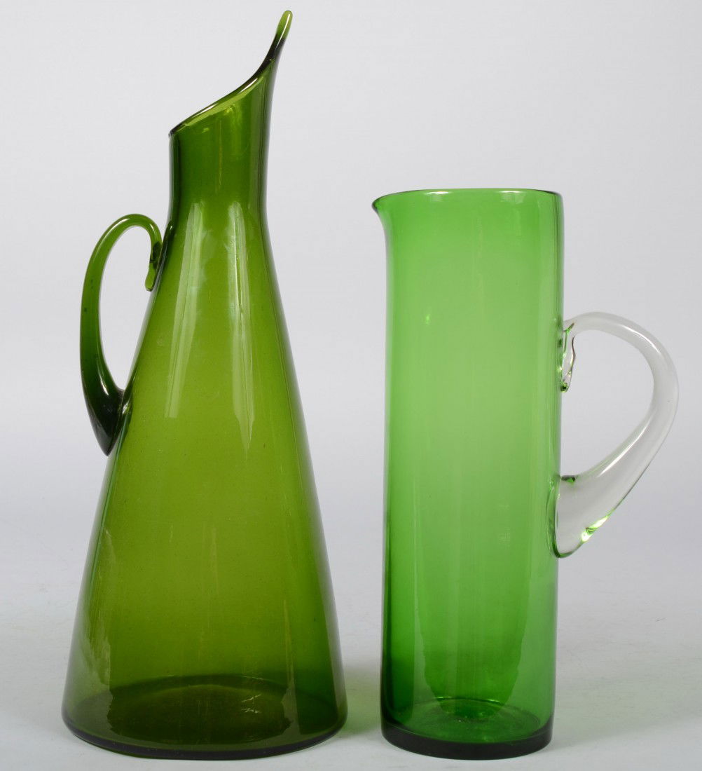 Two Green Blenko Pitchers, a cylindrical lime gree: Two Green Blenko Pitchers, a cylindrical lime green with applied crystal loop handle, pulled spout, unmarked, 13 3/4"h.; a conical form in dark olive with short neck and diagonal cut spout, applied lo