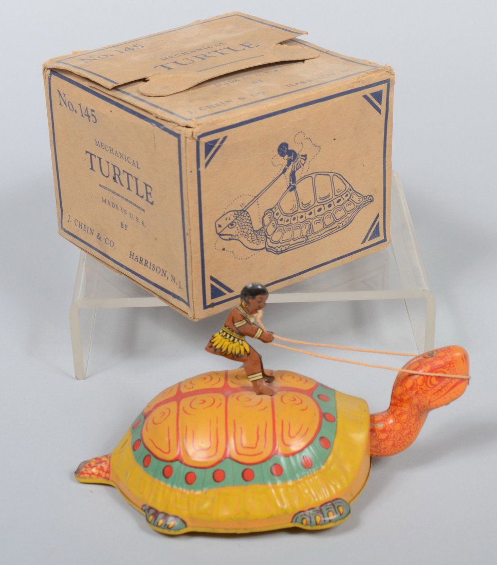 J. Chein No. 145 Mechanical Turtle in Original Box: J. Chein No. 145 Mechanical Turtle in Original Box, polychrome lithographed sheet steel turtle with native on its' back with reins. Marked as titled. 4"h. X 8"l. Condition: Toy: God; Box: a little use