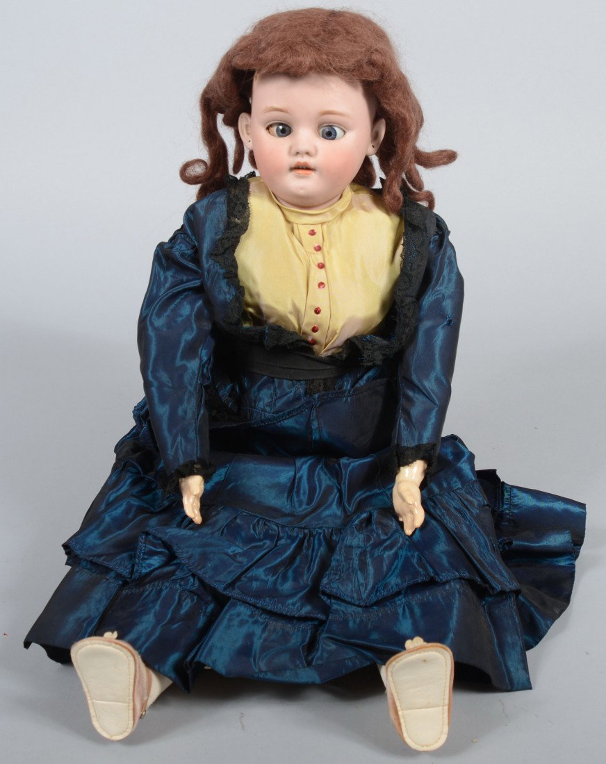 Bisque Head Doll marked: Germany, SK-1080-11 on ba: Bisque Head Doll marked: Germany, SK-1080-11 on back, with blue glass eyes (askew), open mouth, auburn hair (detatched), fabric body and limbs with china hands, calves and feet. 25"l. Condition: Fair.