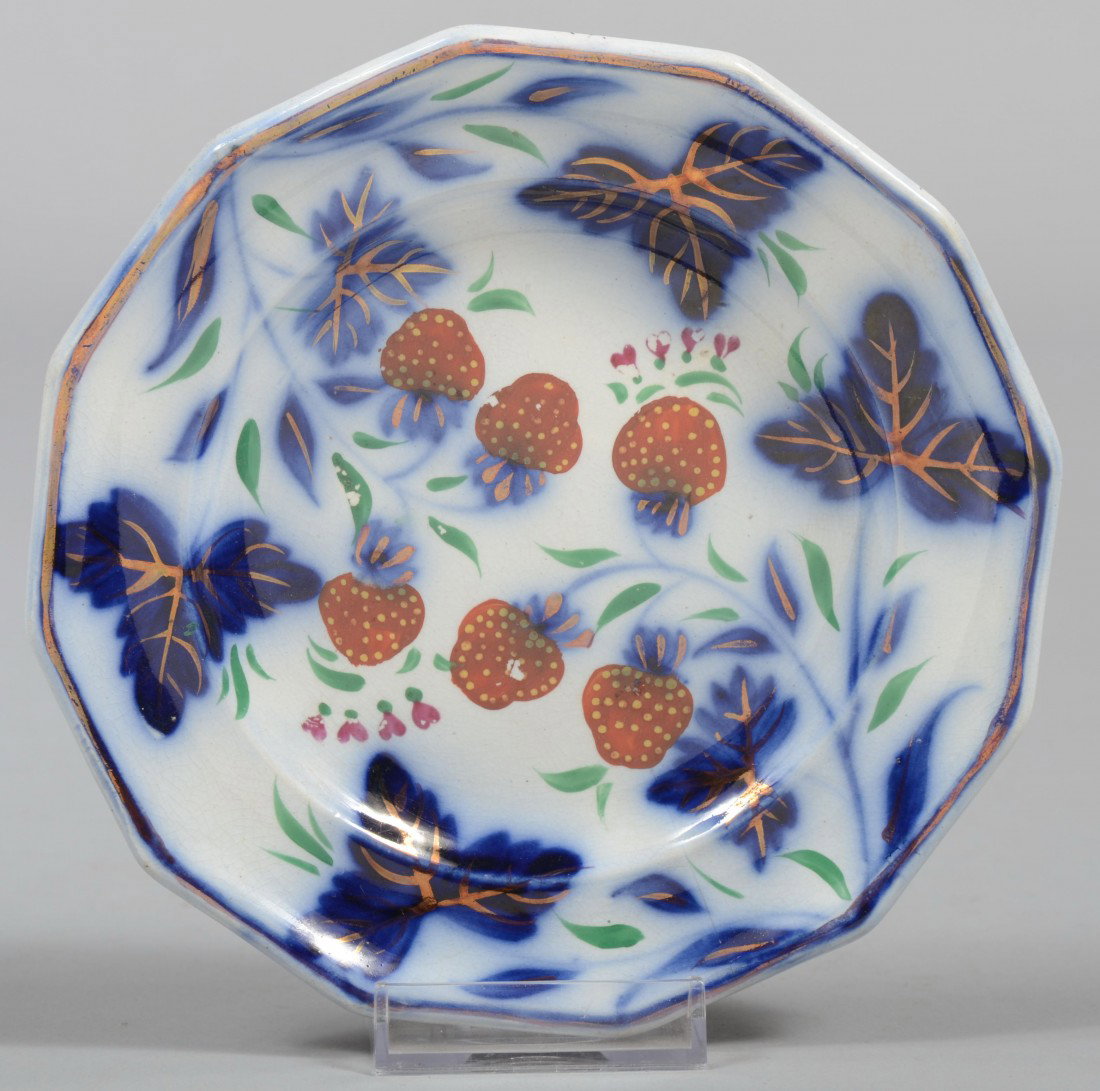 Gaudy Strawberry Ironstone Saucer, 12 sided rim, U: Gaudy Strawberry Ironstone Saucer, 12 sided rim, Under glaze blue leaves with copper luster accents and over glaze strawberries with green leaves. Unmarked. 6" dia. Condition: tight crack from rim to 