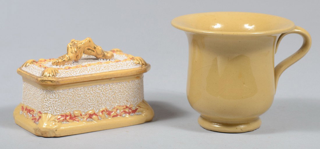 Two Yellowware Pieces, coral decorated match box i: Two Yellowware Pieces, coral decorated match box in casket shape; along with a syllabub cup with applied handle and raised foot. Box marked: "A. Tschinko", box: 3 1/2"l. and cup: 3"h. Condition: 2 tin