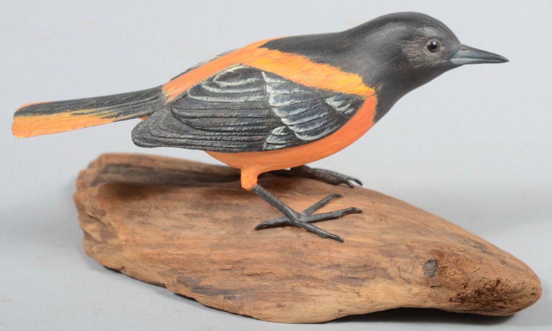Jack Holt signed, Realistic Carved and Painted Nor: Jack Holt signed, Realistic Carved and Painted Northern or Baltimore Oriole. Life-sized carving is mounted on a piece of weathered wood and bears inscription with date, '73, on its' bottom. Bird is 7"