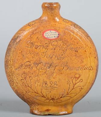 Redware Canteen with Yellow Glaze and Inscribed Te: Redware Canteen with Yellow Glaze and Inscribed Text and Decorations. Possibly Scandinavian, per text dated 1828, with spout and oval foot. 7 1/4"h. Condition: Several chips to base rim.