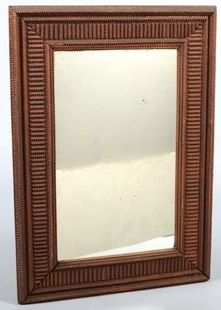 Tramp Art Mirror Frame. Dark stained, tight and f: Tramp Art Mirror Frame. Dark stained, tight and fine chip carved field with perpendicular borders. 23 1/2"h. X 17"w. Condition: Shrinkage to backing board has opened the corner seams, short corner fra