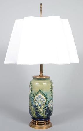Moorcroft Pottery Stylized Peacock Feather Design: Moorcroft Pottery Stylized Peacock Feather Design Table Lamp. Blue to green ground, factory original brass finish mountings with shaped and pleated cloth shade, fully signed with Factory marks and als
