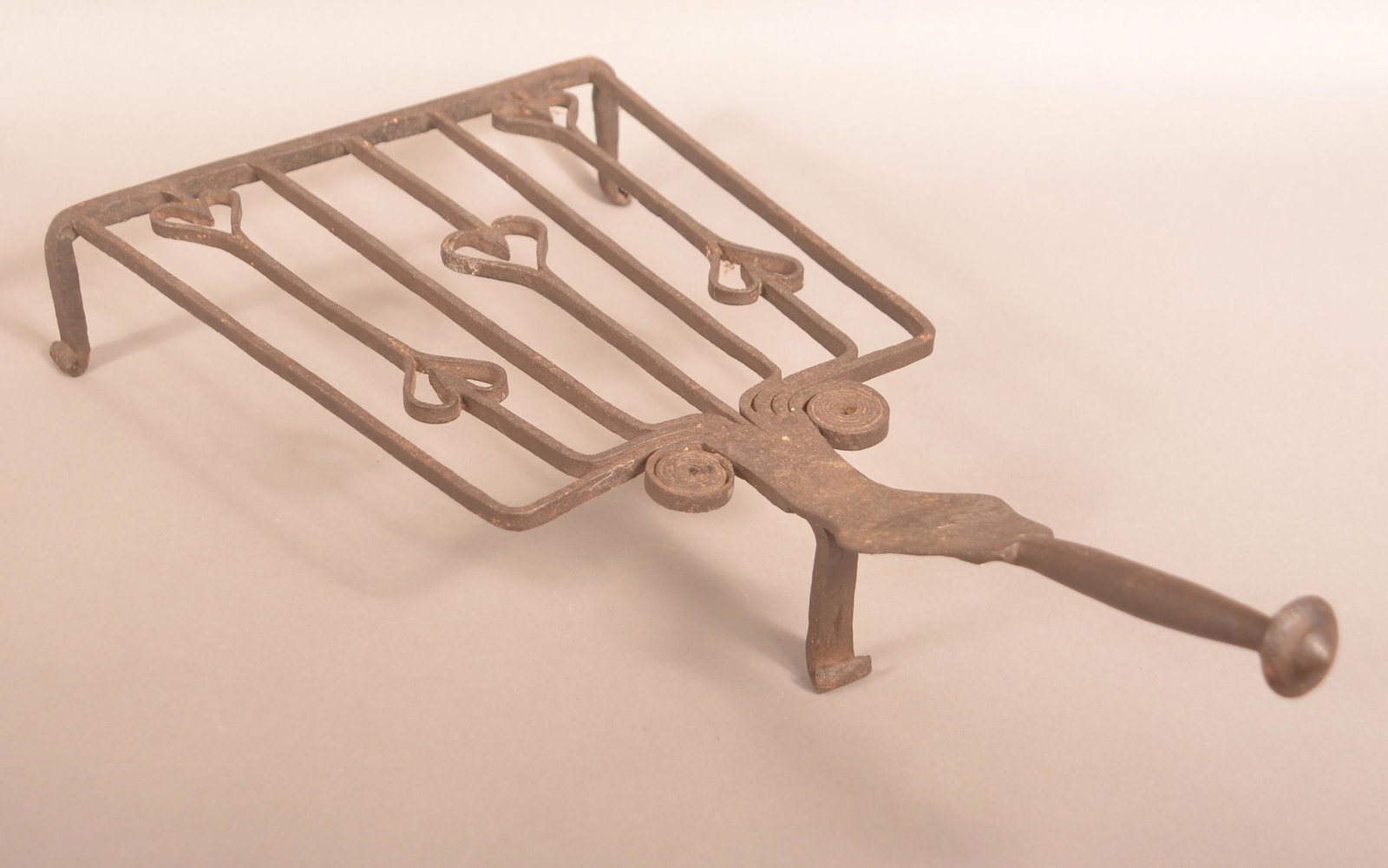 American Early 19th Century Iron Trivet Base Gridiron.: American Early 19th Century Iron Trivet Base Gridiron. Heart and scroll design with flattened to rounded handle. 24"l. Condition: Good with even pitting and rust.