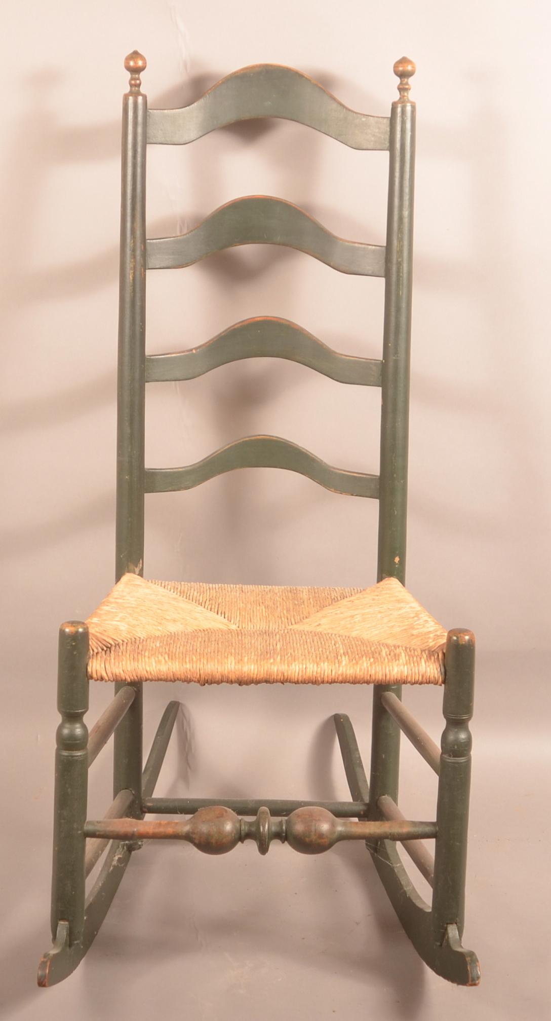 Delaware Valley Arched Ladder-Back Rocking Chair.: Delaware Valley Arched Ladder-Back Rocking Chair. Old green paint, rush seat and boldly turned front stretcher. 41-1/2"h. overall. Condition: Very good with minor wear.