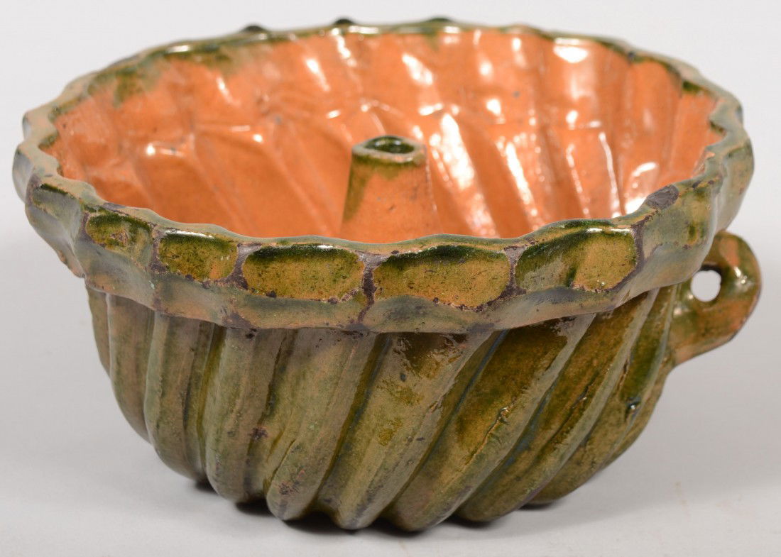 Redware Turk's Head Food Mold. Interior with salt g: Redware Turk's Head Food Mold. Interior with salt glaze and exterior with green slip glaze, folded rim and tab handle with hole. Unmarked. 4 1/4"h. X 9"dia. Condition good.