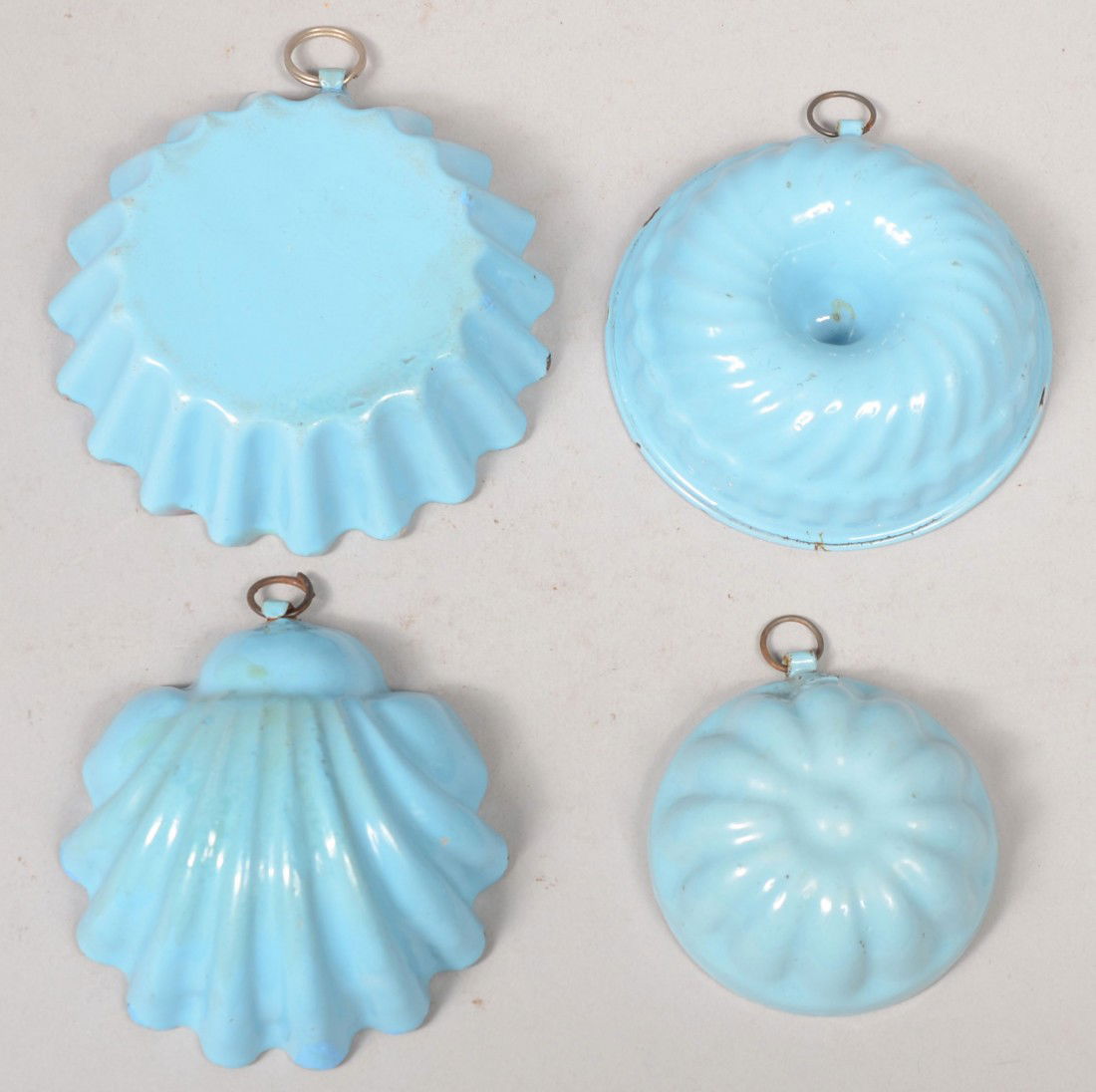 Four Press Formed Food Molds. Solid light blue wit: Four Press Formed Food Molds. Solid light blue with white interior, all with hanging rings. Shell: 3 1/8"dia., Crimped Round: 3 3/4"dia., Large Turk's Head with funnel: 3 1/4"dia., Small Turk's Head: