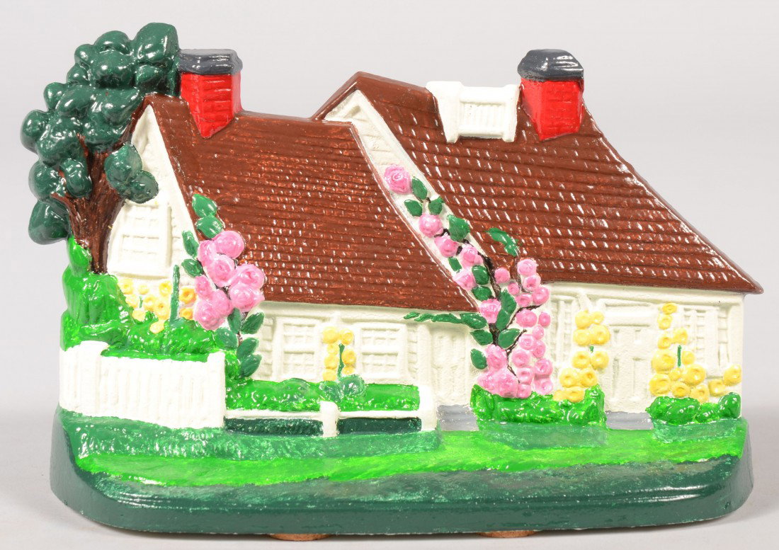 Painted Cottage Doorstop. Realistic painted flower: Painted Cottage Doorstop. Realistic painted flower and vine covered brown roofed cottage with green grass base. 5 1/4"h. Condition: Good.