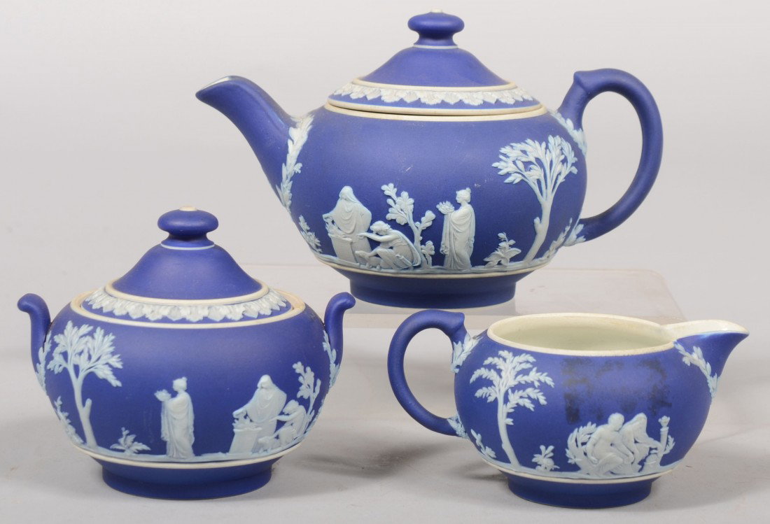 Wedgwood Jasperware, Three Piece Tea Service. Medi: Wedgwood Jasperware, Three Piece Tea Service. Medium Dark Blue with classical women and garland. Modern era marks. Teapot: 4 1/2"d., Covered Sugar: 4"d., Creamer: 3 1/2"d. Condition: Sugar has repaire