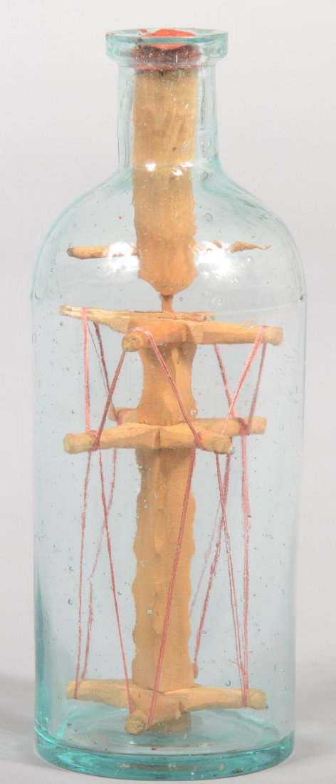 Green Glass Bottle with Carved Wood Whimsy. Three : Green Glass Bottle with Carved Wood Whimsy. Three part molded bottle containing a multi piece carved wood and thread rotating whimsy. Unsigned, but probably by same artist as next lot. 6"h. Condition: