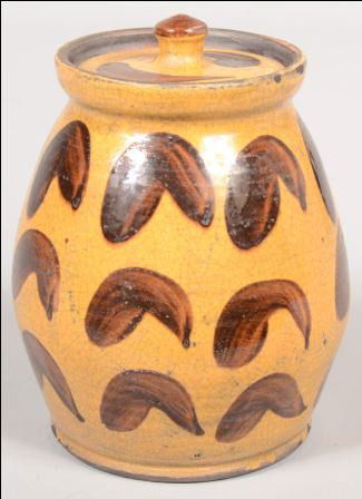 Shooner Contemporary Redware Lidded Jar. Ovoid sha: Shooner Contemporary Redware Lidded Jar. Ovoid shape with yellow ground and manganese comma decorations. Marked on bottom: "Greg Shooner, 1998" 7"h. Condition: Good.