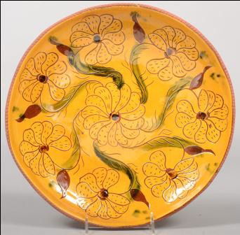 Large Round Deep Redware Charger signed: "L & B Br: Large Round Deep Redware Charger signed: "L & B Breininger, etc. 1972." Yellow slip ground with seven sgraffito flower heads and green accented leaves. Coggle rim. 12 3/4"dia. Condition: Good.