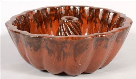 Redware Turk's Head Food Mold. Manganese slip deco: Redware Turk's Head Food Mold. Manganese slip decorates rim inside and out also nose of center cone. 9 3/8"dia. Condition: A chip off outside of rim and roughn ess on cone nose.