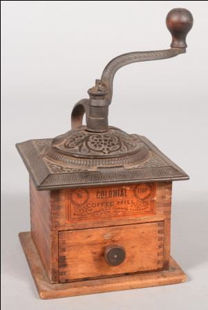 Wooden Box Coffee Grinder with Cast Iron Mill. Lid: Wooden Box Coffee Grinder with Cast Iron Mill. Lid of mill marked with daisies and scrolls. Serpentine crank handle with turned wood knob and loop handle. Original drawer has wood knob. Orange paper l