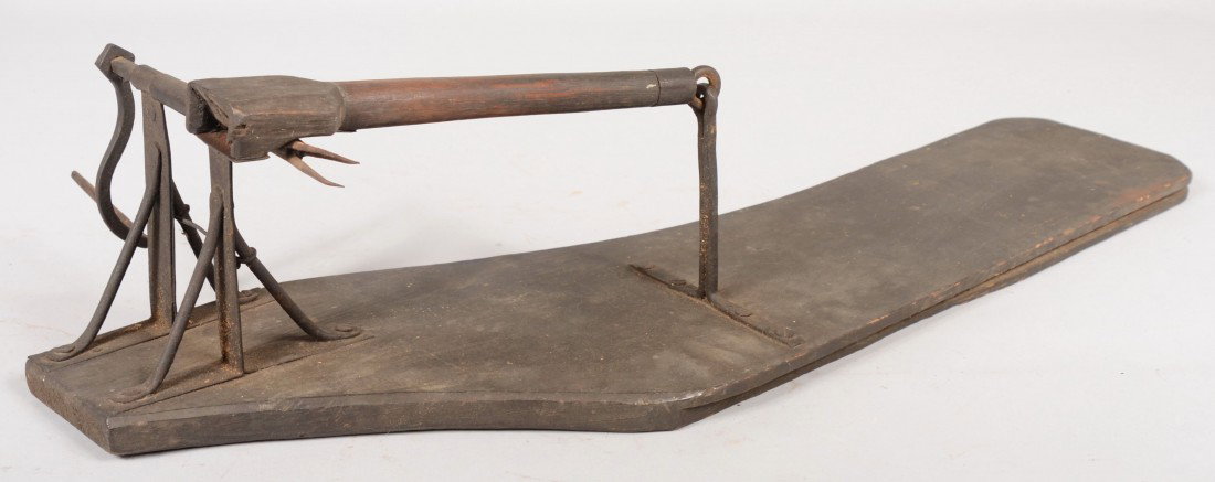 Primitive Apple Peeler. Hand forged iron mechanism : Primitive Apple Peeler. Hand forged iron mechanism attached to a free form cut floor board fragment. 5 1/2"h. X 30"l. Condition: Good with use wear. Crank missing wood handle.