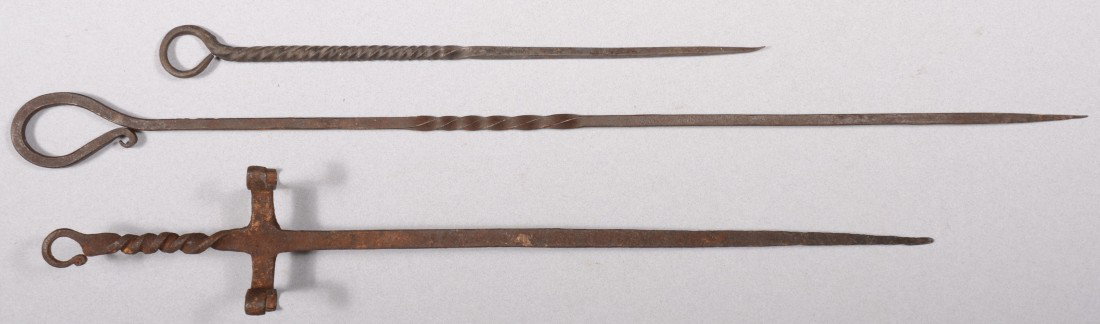 Three Wrought Iron Skewers. A free standing spit s: Three Wrought Iron Skewers. A free standing spit skewer with legs19 1/2"l., and two single twisted skewers. 3 1/2" and 24"l. Condition: Good with use wear.