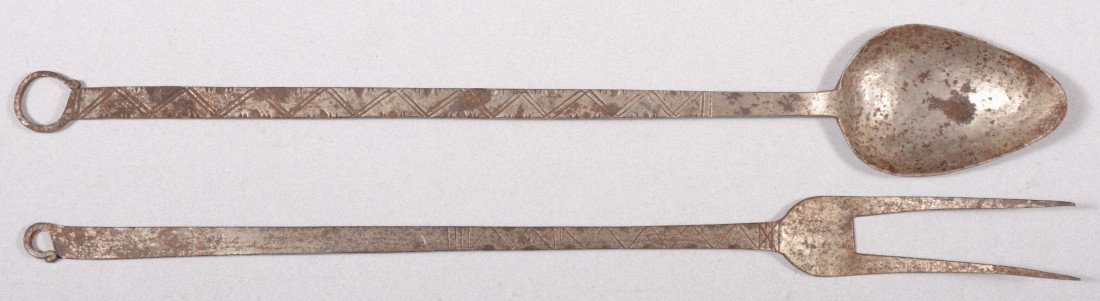 Decorated Wrought Iron Flesh Fork and Spoon. Both : Decorated Wrought Iron Flesh Fork and Spoon. Both handles decorated with cross hatching and lines with side turned hanging loops. Both 18"l. Condition: Good with use wear.