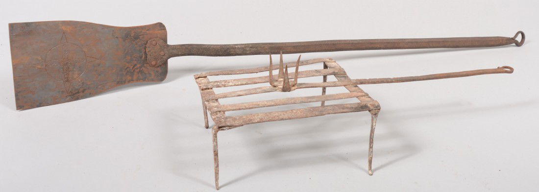 Two Wrought Iron Hearth Tools. A grid iron type tr: Two Wrought Iron Hearth Tools. A grid iron type trivet with a spiked socket on top. Strap handle with hanging loop, 6 1/2"h. X 21 1/2"l. Along with a peel. Chamfered handle with hanging loop, shaped f