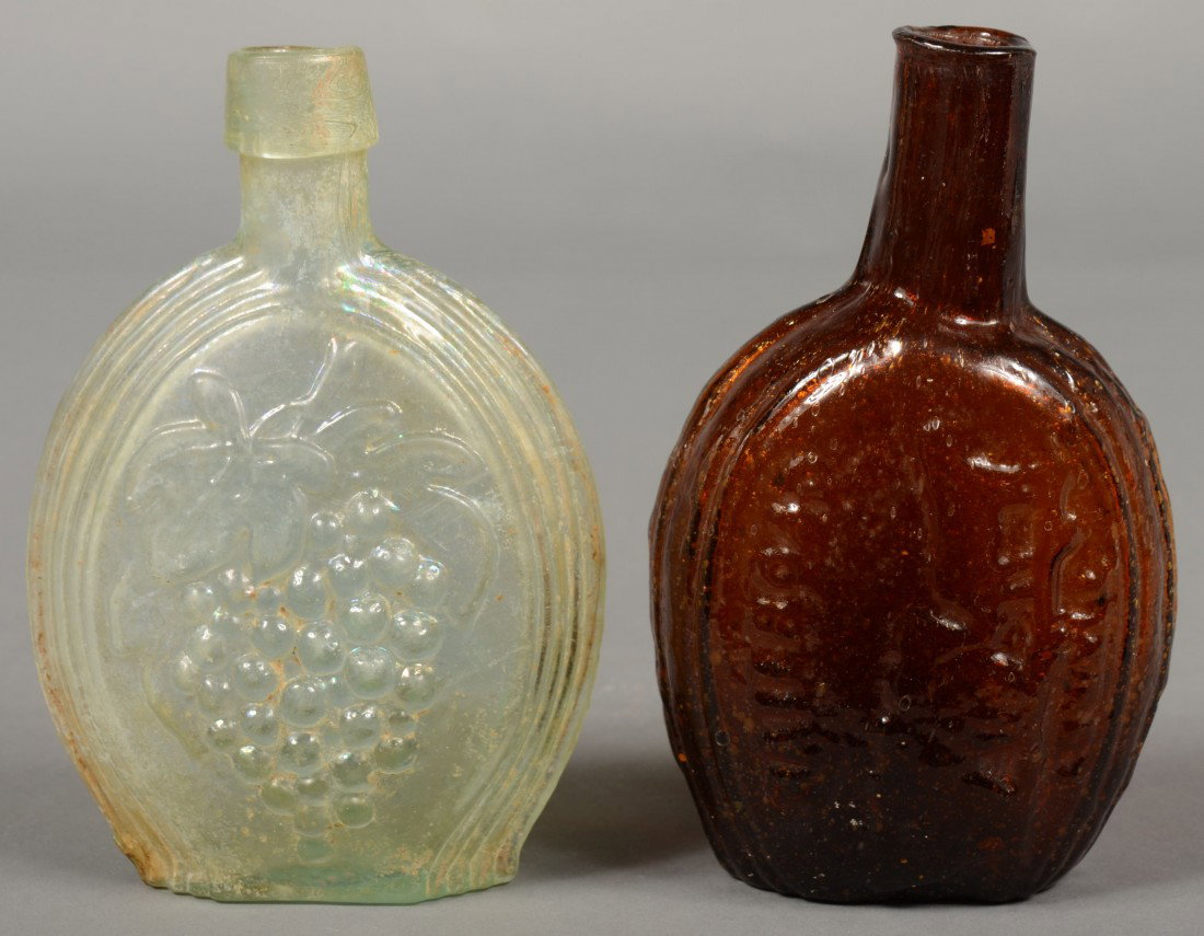 Two Pictorial Flasks; 1st is an iridescent aquamar: Two Pictorial Flasks; 1st is an iridescent aquamarine glass Sheaf of Rye/Bunch of Grapes half pint pictorial flask, (McKearin GX-3) with tapered lip and pontil mark. 6" high. 2nd is a deep amber glass