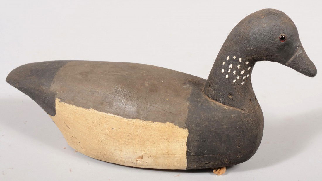 Primitive Carved and Painted Male Brant Decoy. Bla: Primitive Carved and Painted Male Brant Decoy. Black breast and head with white spotted neck and glass eyes. White and gray body and black tail. Flat lead weight on bottom and tether ring at front. Un