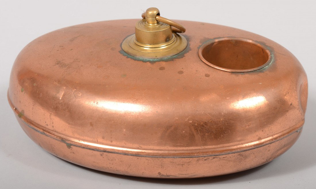 Oval Copper Hot Water Bed Warmer. Container has th: Oval Copper Hot Water Bed Warmer. Container has threaded brass cap with ring and the top has a cavity for a cup or additional embers. 5 1/2"h. X 12 1/2"l. Condition: Dent on one end with solder repair