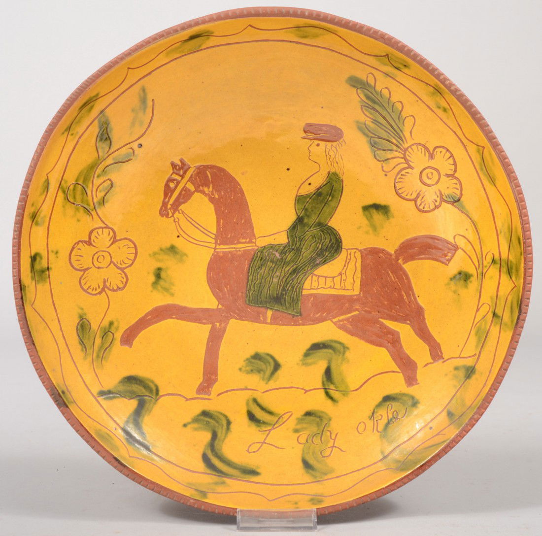 L.&B. Breininger Redware Charger. Featuring a scra: L.&B. Breininger Redware Charger. Featuring a scraffito design of a woman on horseback with flowers on a yellow slip ground with green slip dress and leaves and a coggle rim. Back side shows names and