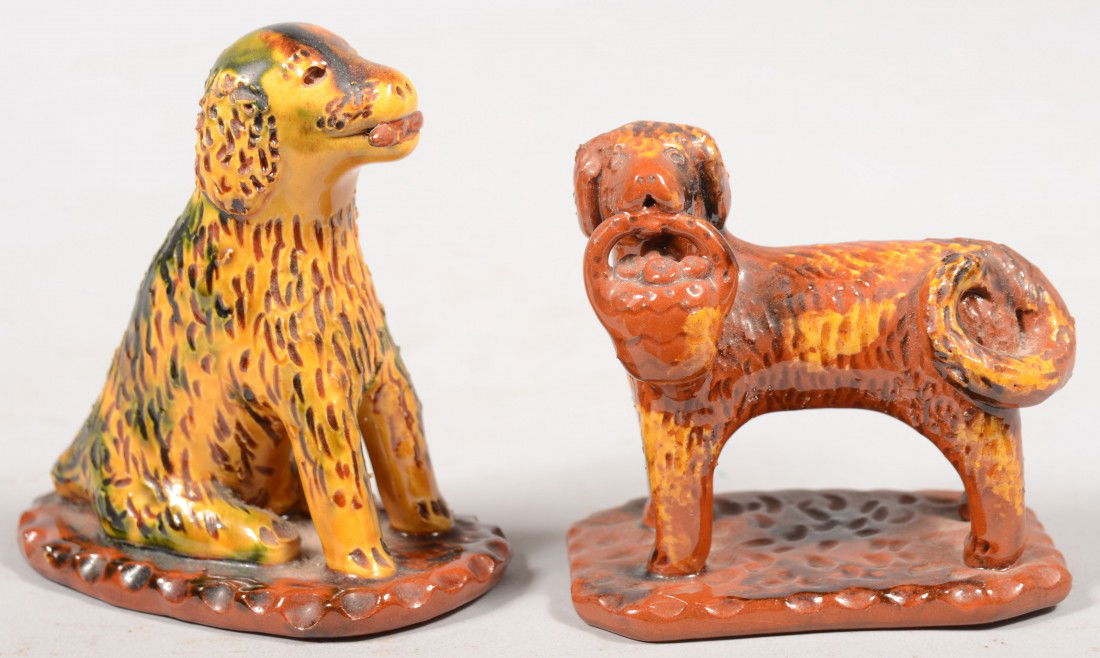 Two L. Breininger Redware Dogs. Scalloped edge bas: Two L. Breininger Redware Dogs. Scalloped edge base with standing dog and fruit basket in mouth in red with yellow slip, signed and dated 1997. 3 1/2"h. X 3 1/4"l. Along with a scalloped edge seated d