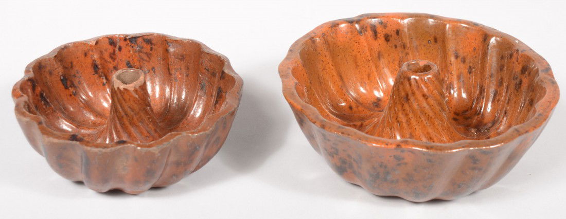 Two 'Turk's Head' Redware Food Molds. Of differing: Two 'Turk's Head' Redware Food Molds. Of differing sizes, each has manganese spatter decoration inside and outside. 7 7/8"dia. and 6 1/2"dia. Condition: Larger good, no damage. Smaller has use wear ch