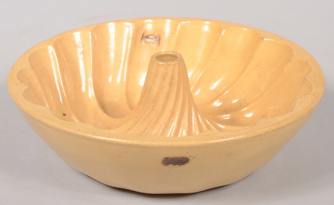 Yellowware Turk's Head Food Mold. Sixteen flute sp: Yellowware Turk's Head Food Mold. Sixteen flute spiral. 10 1/4"dia. Condition: Stone 'pop' in wide end of one flute and a small chip off a rib. Rim and nose good.