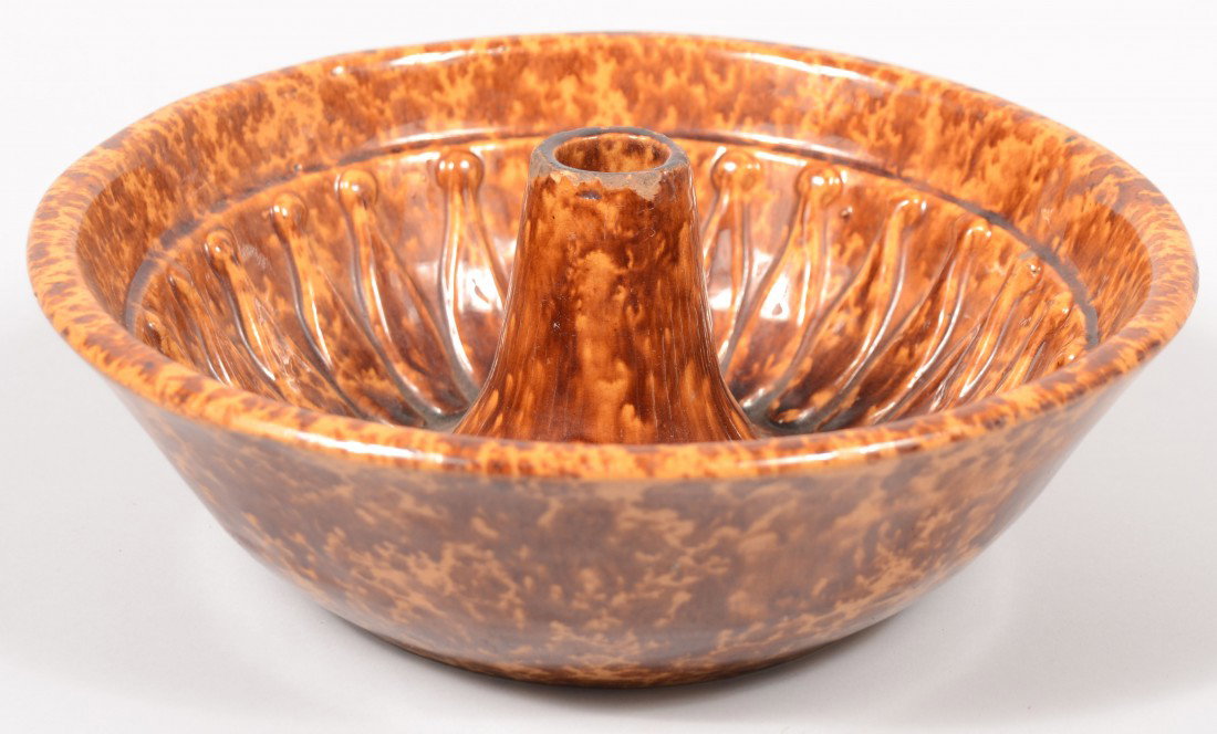 Large Round Rockingham Glazed Yellowware Food Mold: Large Round Rockingham Glazed Yellowware Food Mold. Smooth bowl like sides with petal interior design and funnel shape nose. 3 1/4"h. X 10 1/4"dia. Condition: Good with use wear chipping around nose r