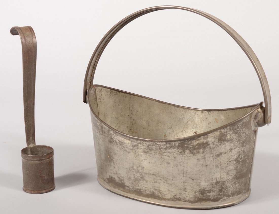 Tinned Sheet Iron Oval Basket with Swing Handle. W: Tinned Sheet Iron Oval Basket with Swing Handle. Wire rolled rim and handle edges. 9 1/2"h.(handle up) X 10 1/4"l. X 6 1/4"w. Along with a tinned sheet iron cream dipper: 8 1/4"l. Condition: good with